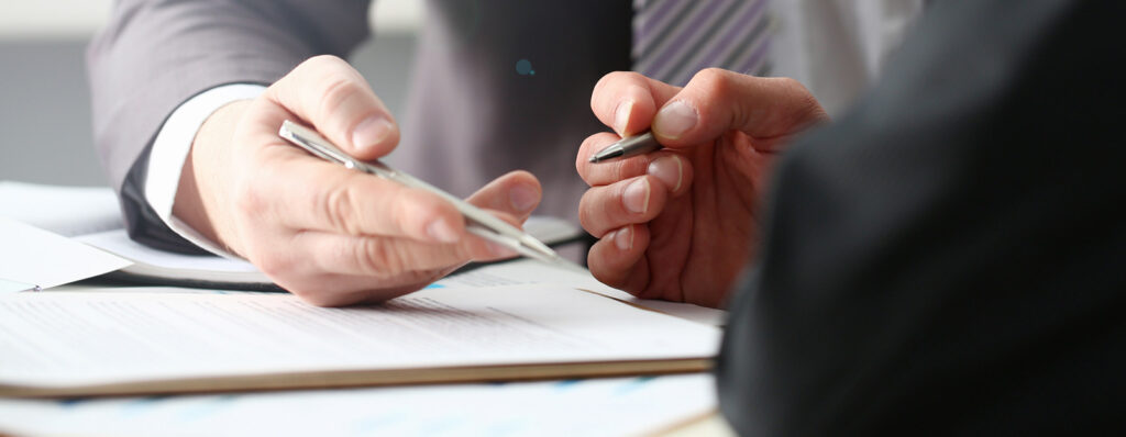 Photo to two people reviewing a document together.